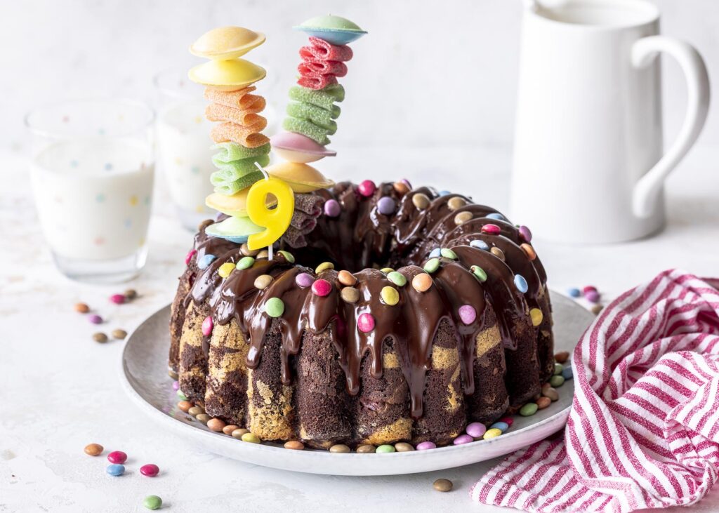 Marmorkuchen mit Kirschen und Smarties. Perfekt für den nächsten Kindergeburtstag. Ein saftiges Kuchenrezept mit Schokoladenglasur.