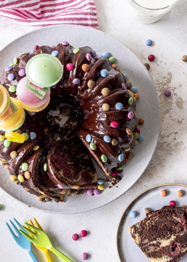 Marmorkuchen mit Kirschen und Smarties. Perfekt für den nächsten Kindergeburtstag. Ein saftiges Kuchenrezept mit Schokoladenglasur.